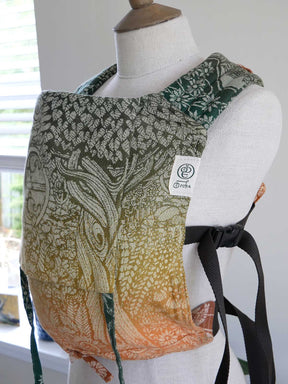 Patterned baby carrier on a mannequin with a visible brand label.