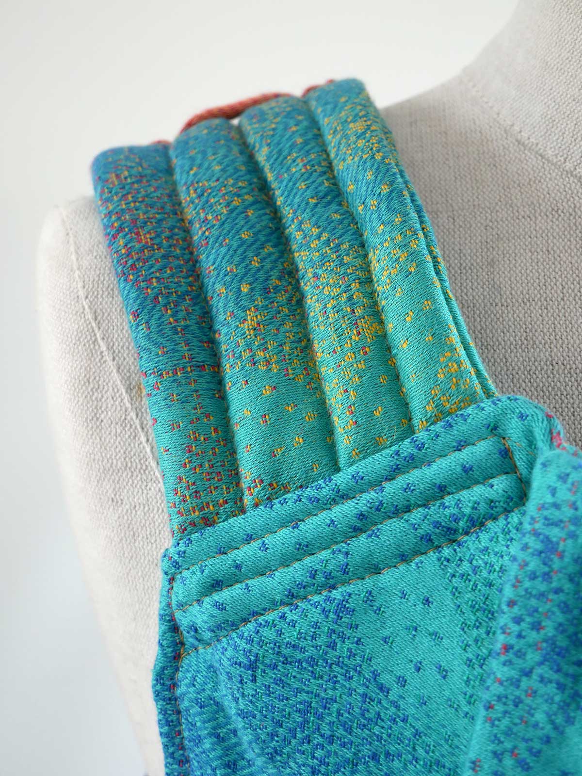 Close-up of a textured turquoise fabric with speckles on a neutral background