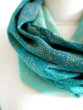 Close up of cowl with teal fade and gold details on mannequin