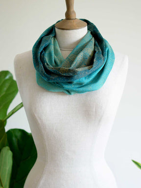 Front view of cowl with teal fade and gold details on mannequin