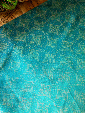 Fabric with teal fade and gold stars laid on table