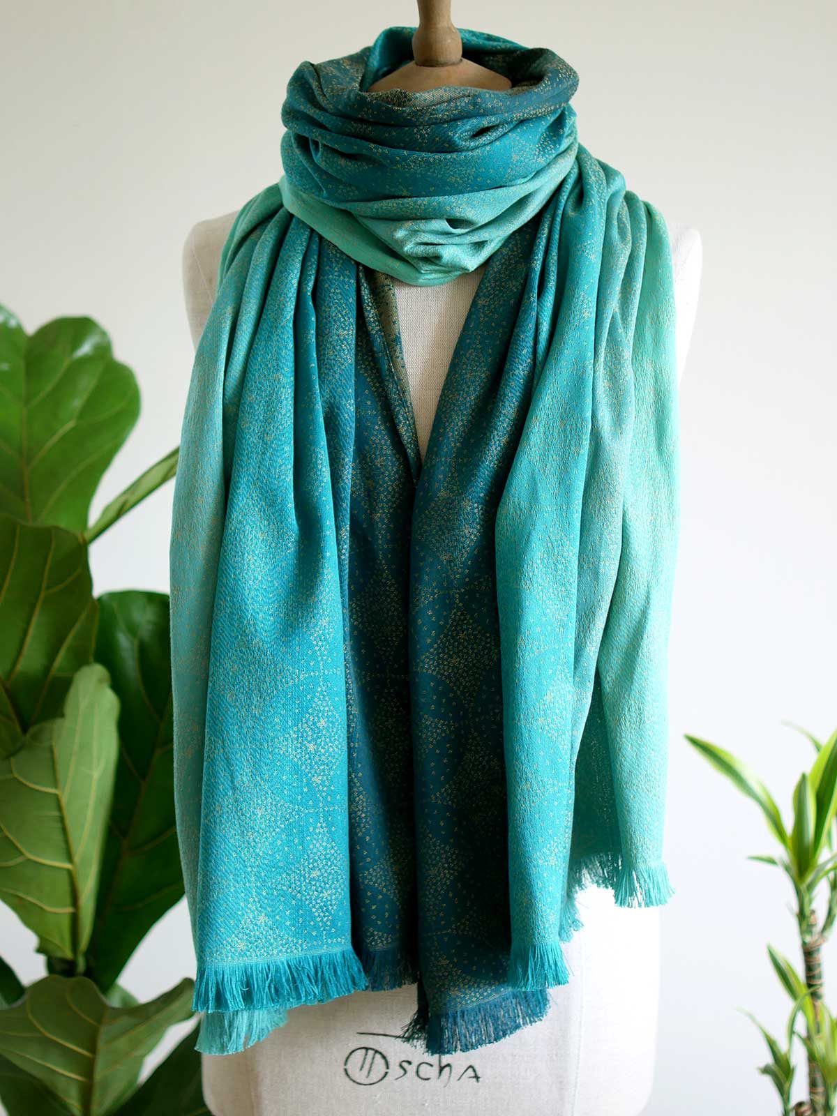 Front view of scarf with teal fade and gold details on mannequin