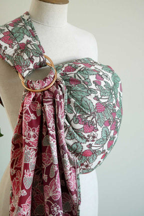 Mannequin wearing a strawberry-patterned ring sling with a gold ring on a white background