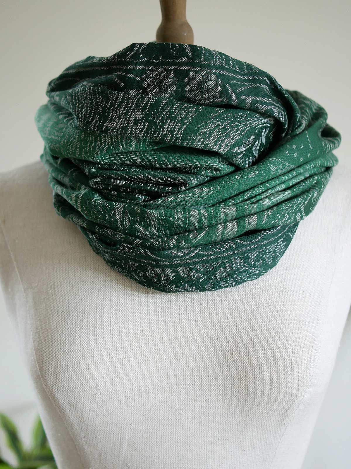 Infinity Loop folded round neck of mannequin. Green soft fabric. 