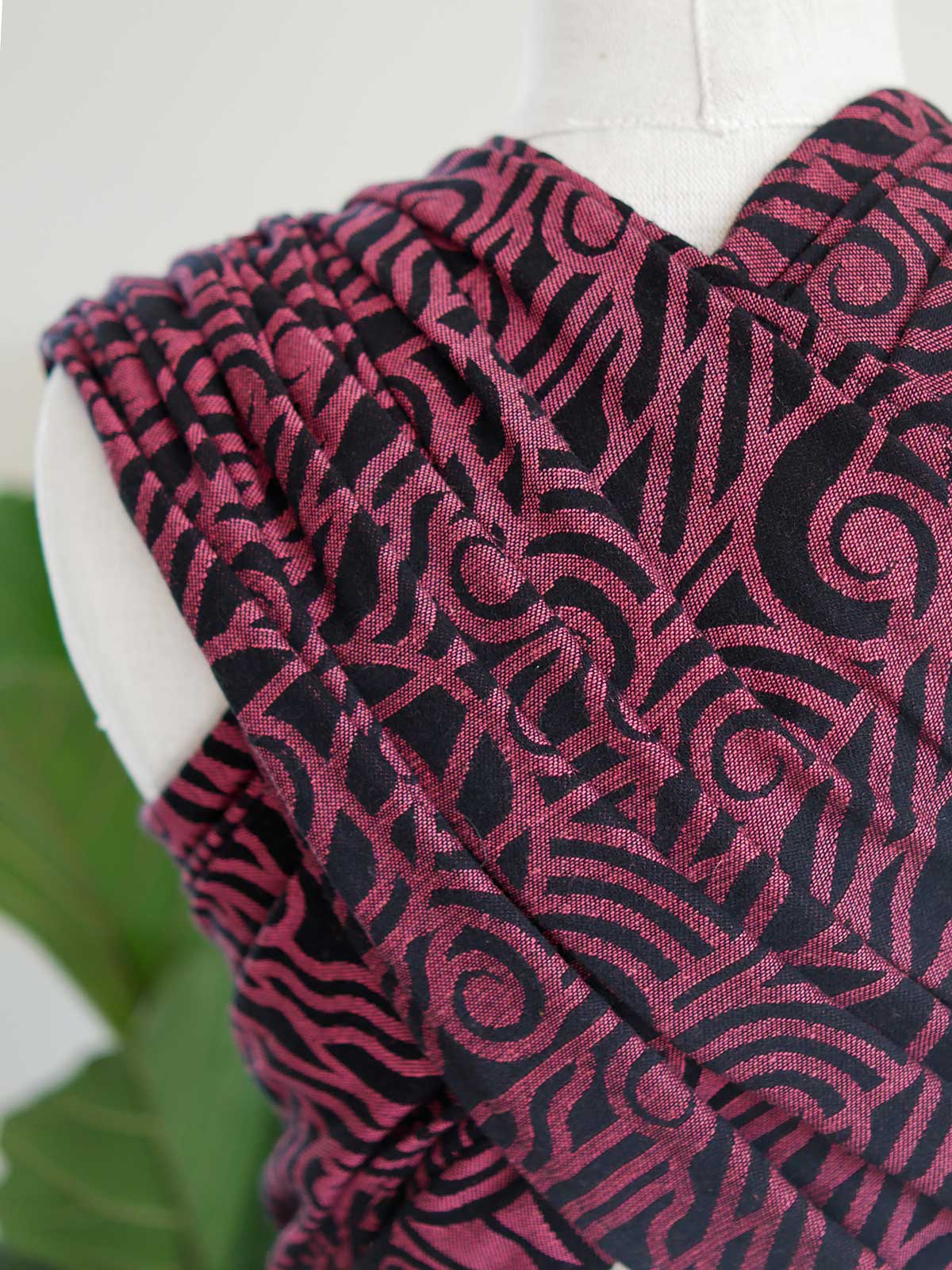 Close up of a black wrap with pink art deco pattern on a mannequin
