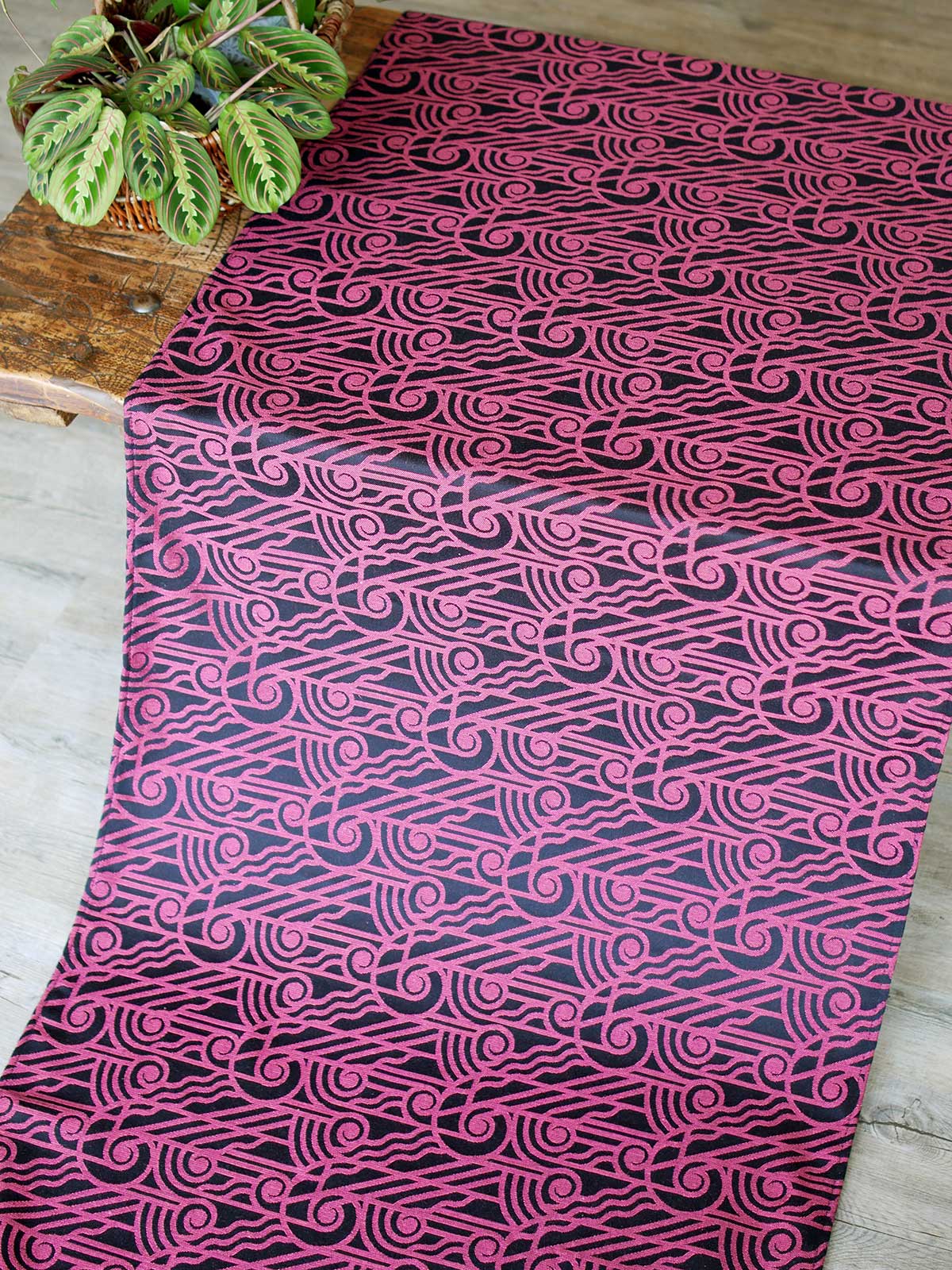 Black wrap with pink art deco pattern laid over a wooden table
