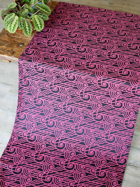 Black wrap with pink art deco pattern laid over a wooden table