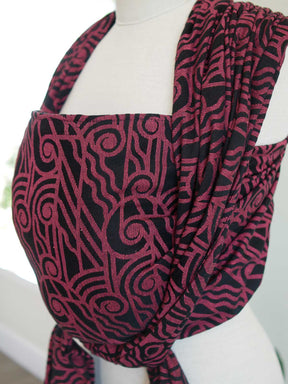 Side view of a black wrap with pink art deco pattern on a mannequin

