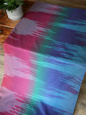 Fabric laid on a wooden table in jewel tones