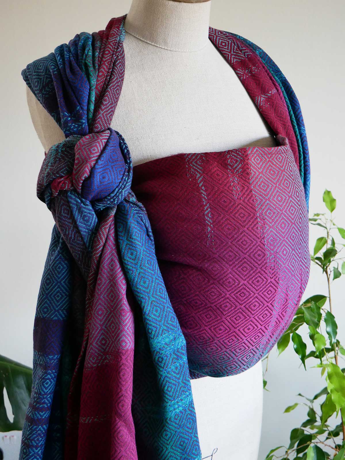 Side profile of Whistle Ice Floe baby wrap on a mannequin in jewel tones