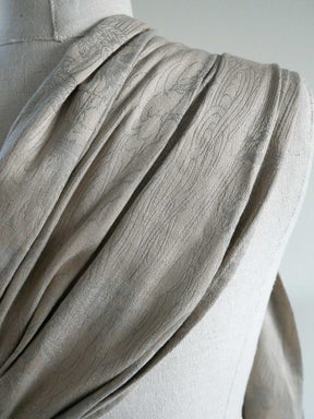 Close-up of a draped fabric on a mannequin with a neutral background