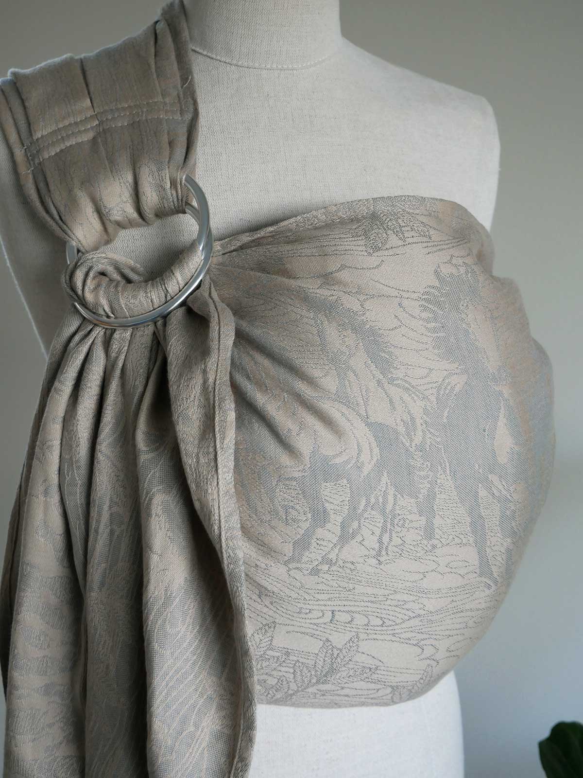 Textured beige ring sling on a mannequin against a neutral background