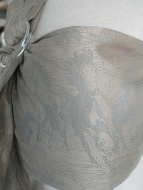 Close-up of a neutral textured ring sling with a horse pattern on a white background