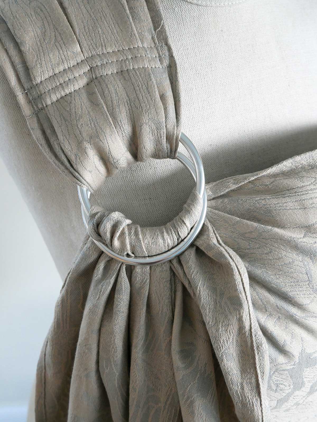Close-up of a beige fabric with a metal ring attached, on a white background