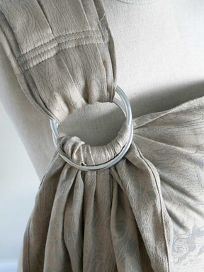 Close-up of a beige fabric with a metal ring attached, on a white background