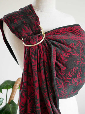 Mannequin wearing a red and black ring sling with a gold ring detail.