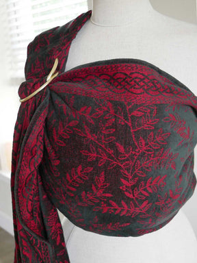 Red and black patterned scarf on a mannequin against a white background