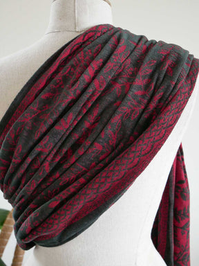 Red and black patterned ring sling on a mannequin against a white background