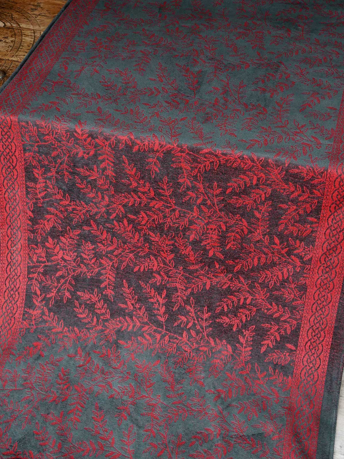 Textile with red and black pattern on a wooden floor