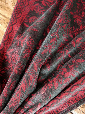Close-up of red and black patterned fabric on a wooden surface