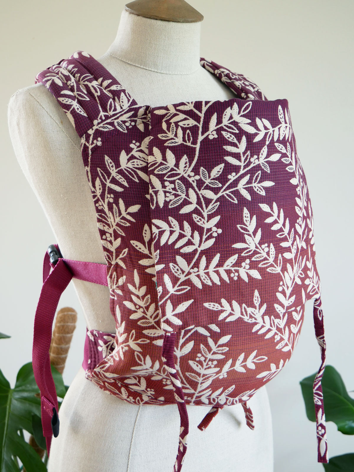 Willow leaf patterned baby carrier on a mannequin against a white background