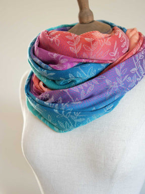 Colorful scarf with floral pattern on a mannequin against a plain background