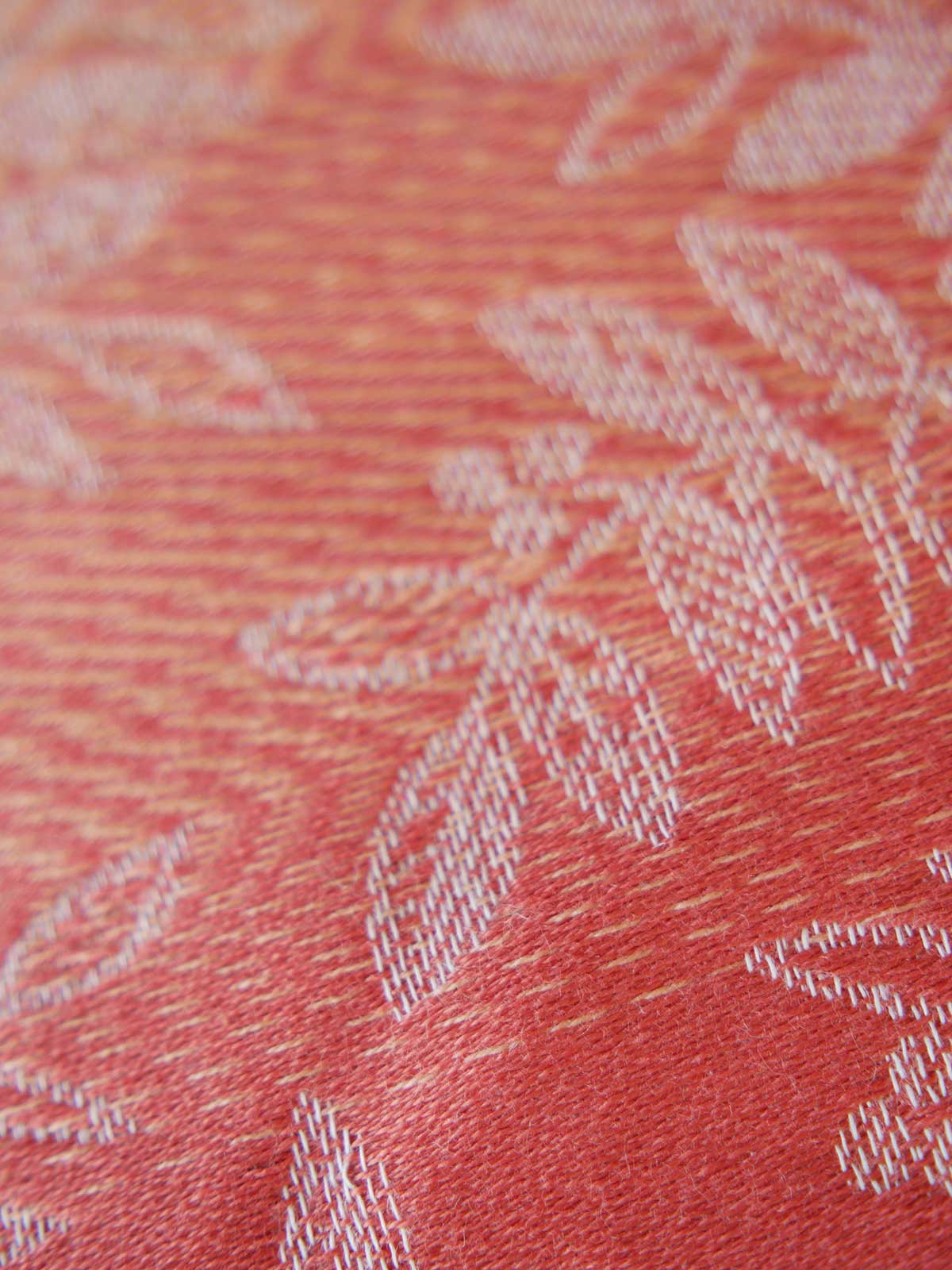 Close-up of a textured fabric with floral patterns on a red background