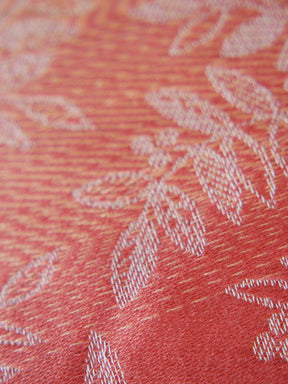 Close-up of a textured fabric with floral patterns on a red background