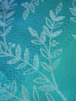 Close-up of a teal fabric with white leaf pattern