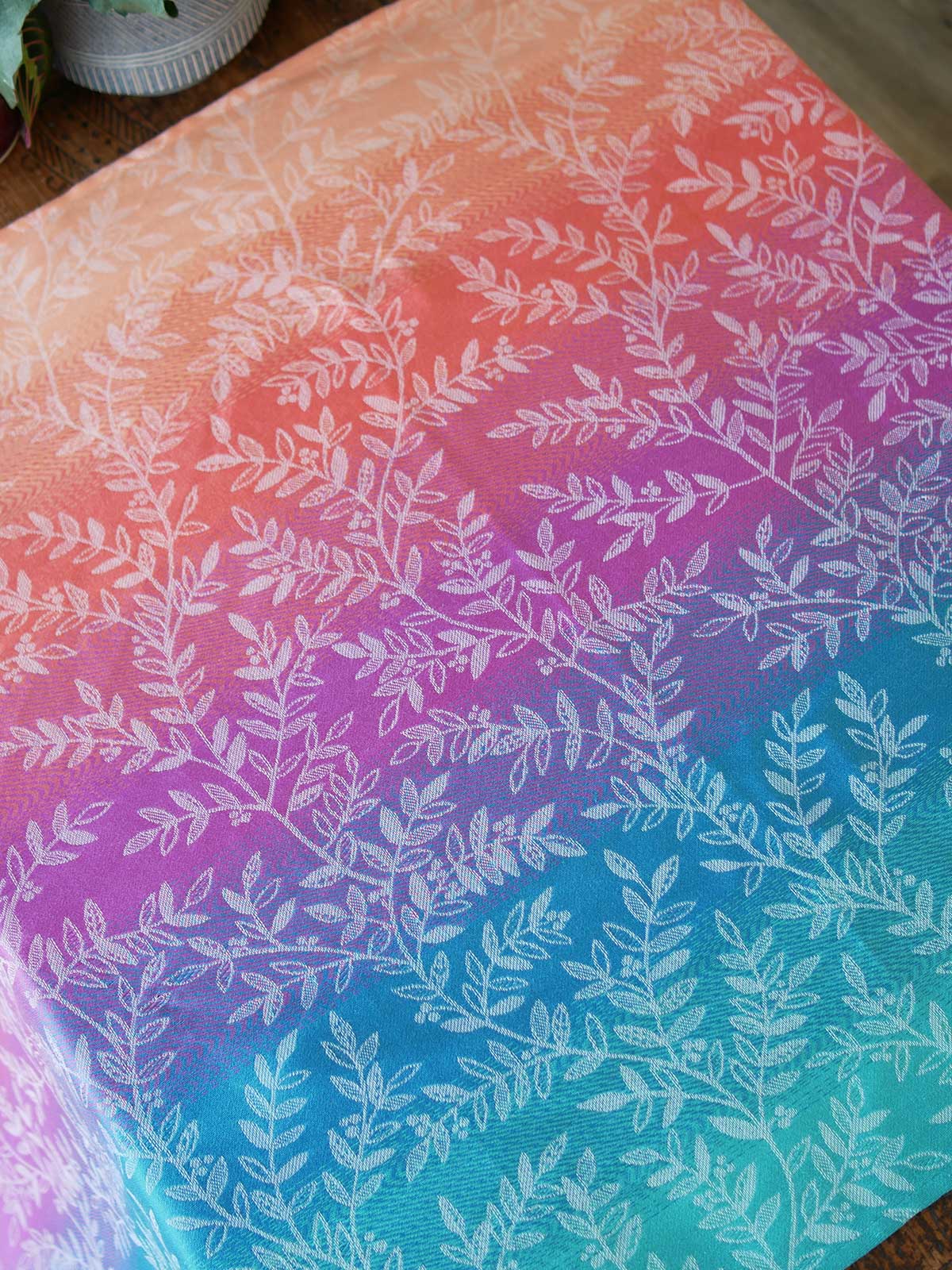 Colorful fabric with white leaf pattern on a gradient background