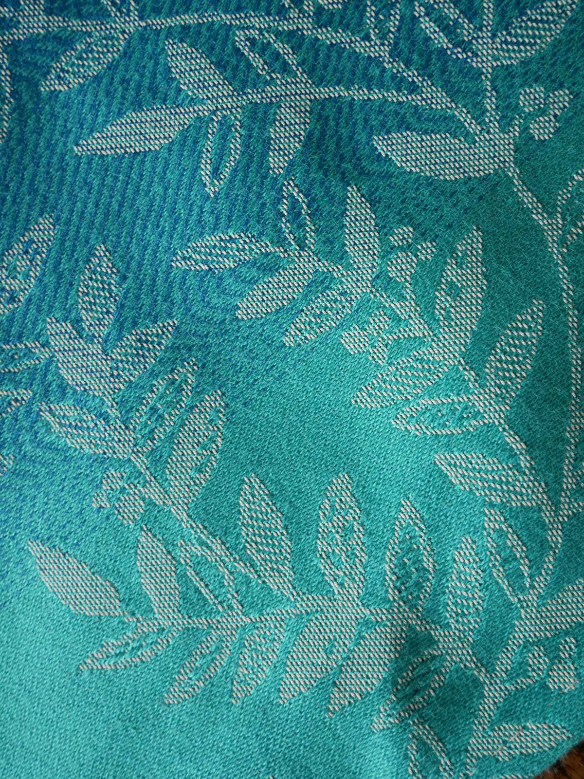 Close-up of teal fabric with leaf pattern