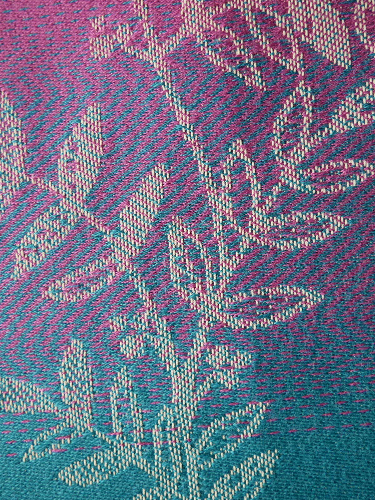 Close-up of a textured fabric with a geometric pattern in pink and blue.