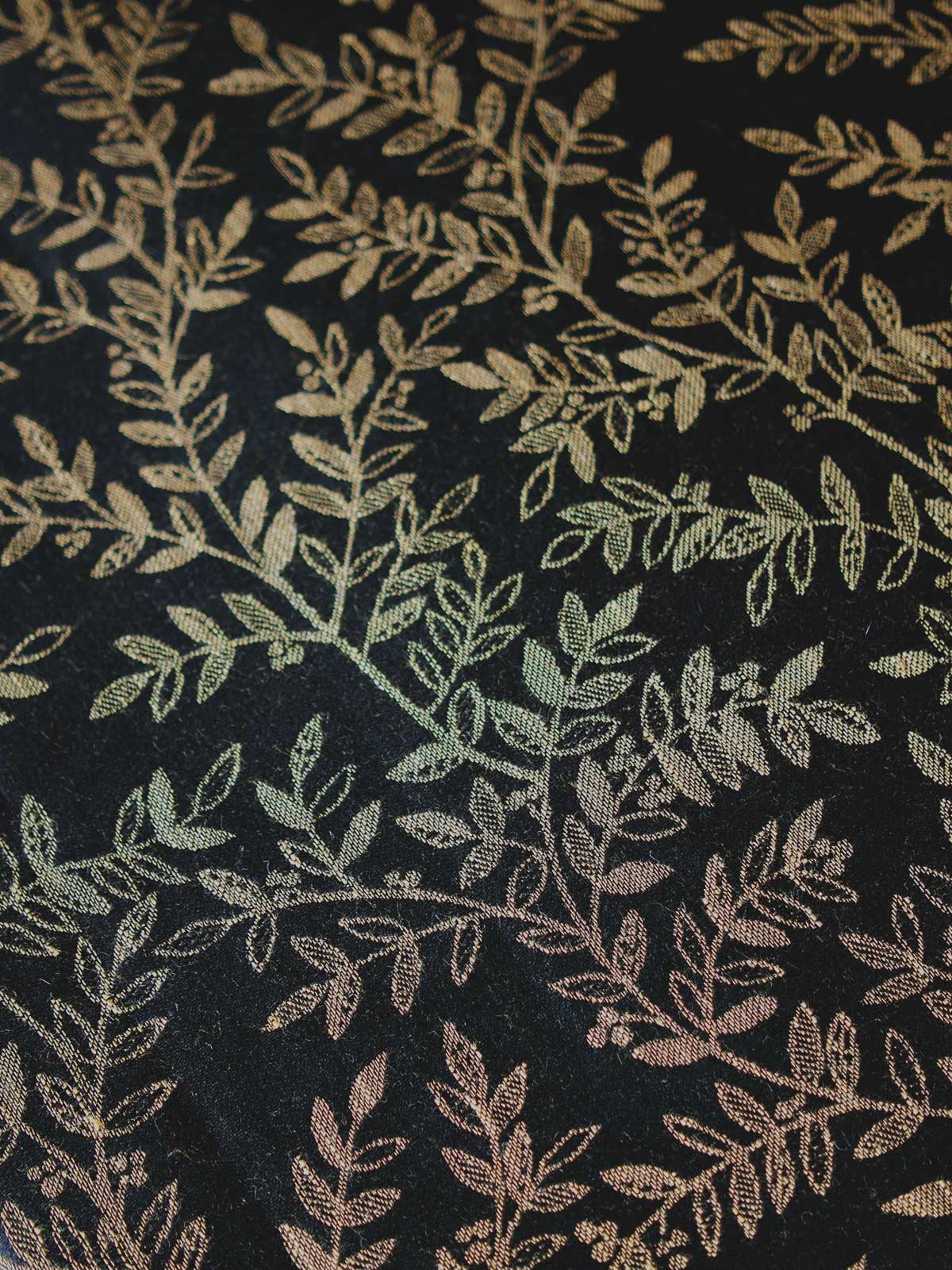 Close up of a black fabric with golden leaves