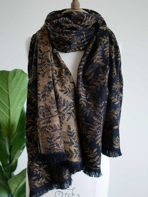 Black scarf with golden leaves draped on a mannequin