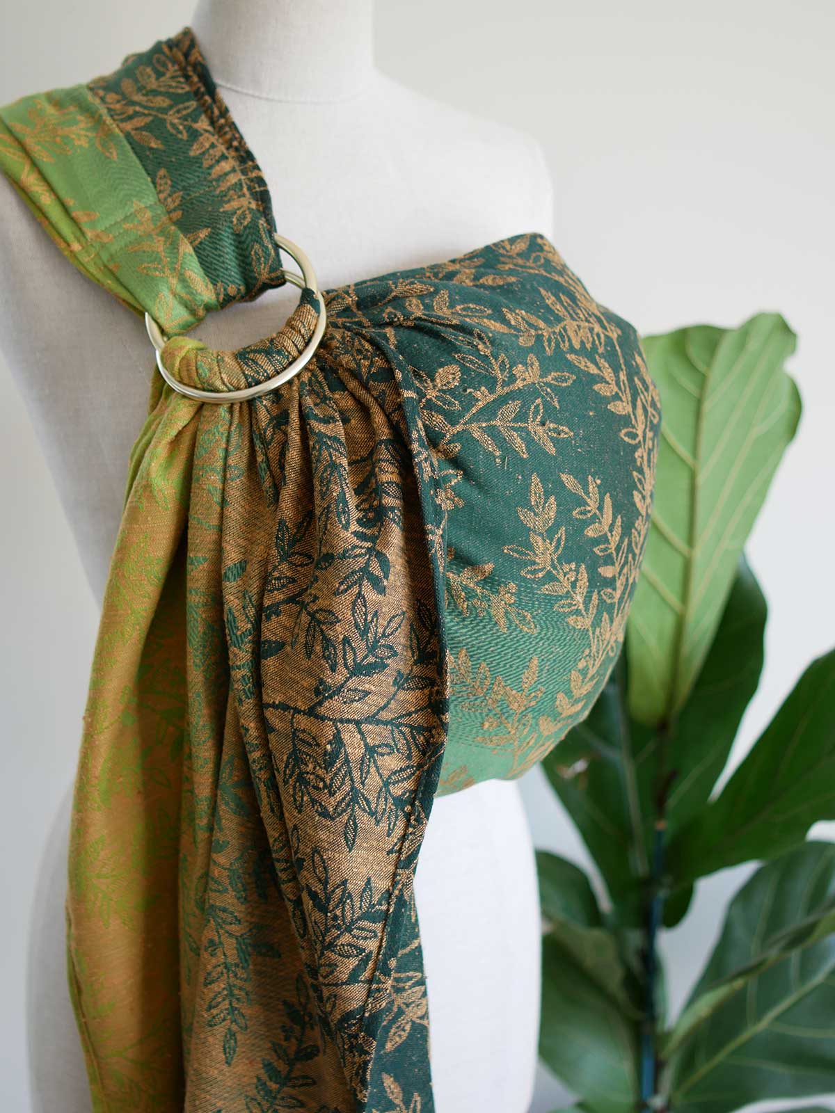 Side view of green ring sling with gold leaf pattern on a mannequin