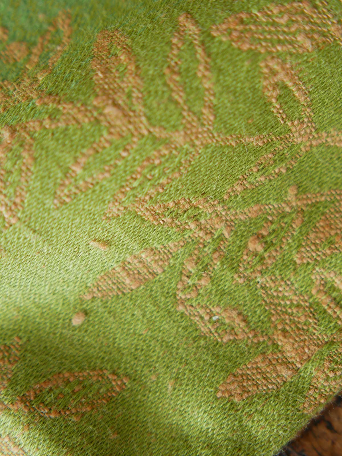 Close up of green fabric with gold leaf pattern 
