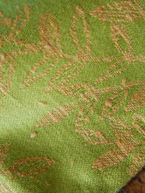 Close up of green fabric with gold leaf pattern 
