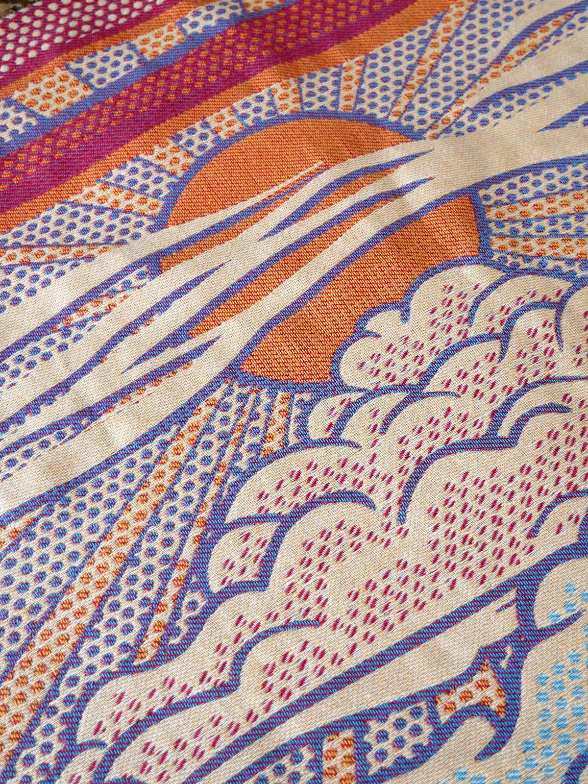 Close-up of a colorful fabric with abstract patterns in orange, purple, and blue.
