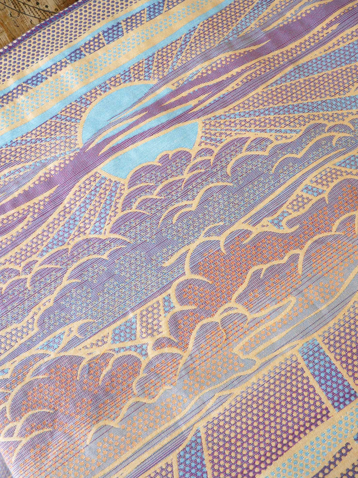 Reverse of a patterned fabric with blue, purple, and orange colors.