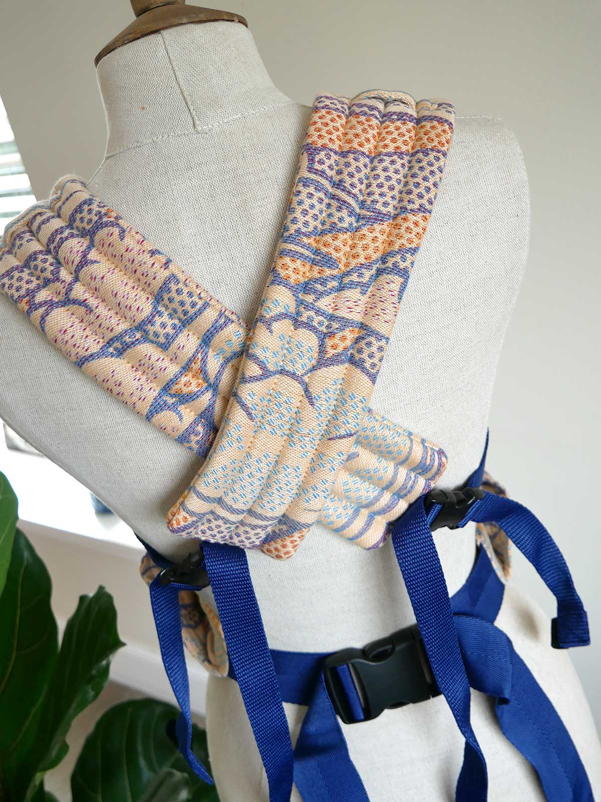 Patterned carrier straps on a mannequin with blue straps.