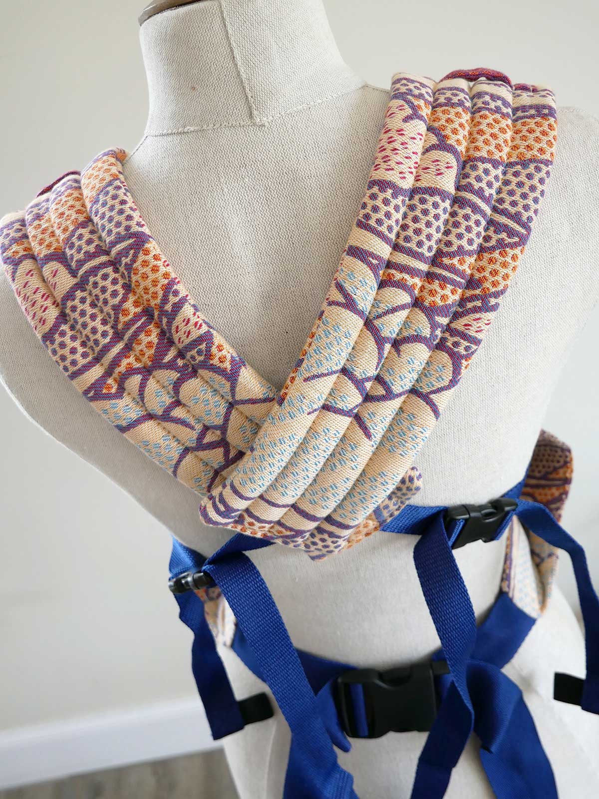 Patterned fabric wrap on a mannequin with blue straps