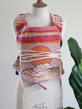 Colorful patterned baby carrier on a mannequin with a white background
