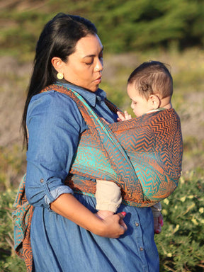 Mother carrying child in baby wrap. 