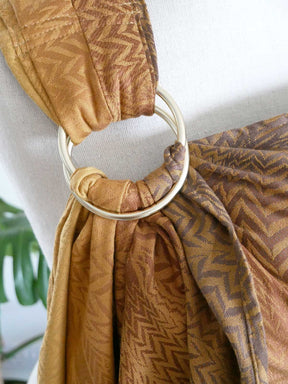 Brown patterned fabric with a gold ring on a white background